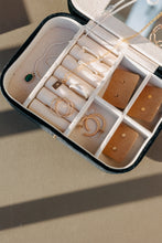 Load image into Gallery viewer, An open jewelry box featuring the Alphabet Initial Rectangle Necklace, alongside gold filled and sterling silver necklaces, hoop earrings, and empty earring holders, arranged on a beige surface with sunlight casting soft shadows.
