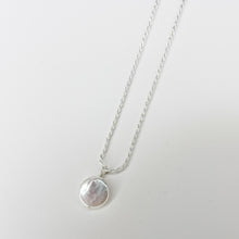 Load image into Gallery viewer, The Coin Pearl Pendant features a delicate sterling silver chain adorned with a round, iridescent coin pearl, beautifully showcased against a plain white background.