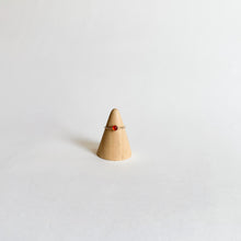 Load image into Gallery viewer, The Carnelian Thin Band Ring | Size 4 is a delicate piece crafted in 14K gold-filled metal, featuring a small red carnelian stone on a slim band, shown displayed on a wooden cone against a plain white background.